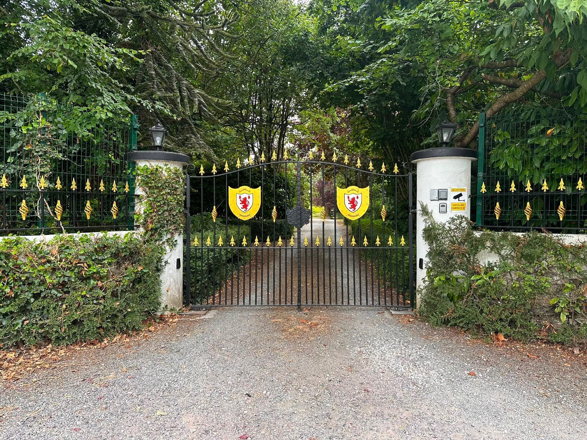 A gated entrance with a cobblestone path leading through.