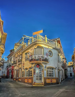 A historic building with a balcony, a sign reading 'Sevillano,' and a 'La Taverna' entrance. - House Sleeps 4 With Pool and Parking (Nerja)