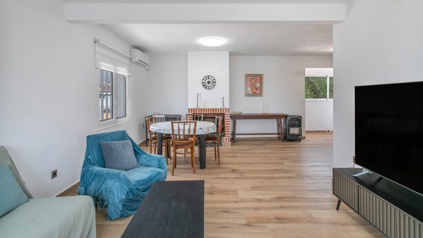A living room with a sofa, a TV, a dining area with chairs and a table, and a fireplace. - Villa 'Espectacular chalet con piscina privada y barbacoa cerca de Alicante , san juan y el Campello' (Alicante (Alacant))