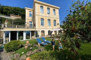 Un bâtiment à deux étages dot é d’un balcon, d’une piscine et d’un jardin bien entretenu.