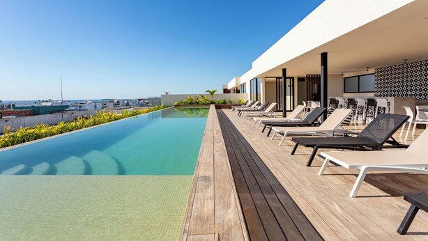 Ein moderner Poolbereich im Freien mit Liegestühlen und Meerblick.