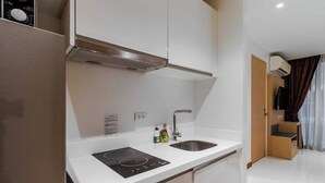 Una cocina moderna con estufa integrada, un lavamanos y una campana extractora.