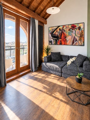 A living room with a sofa, a coffee table, and a painting on the wall.