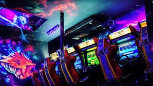 A row of gaming chairs with a neon-lit gaming setup.