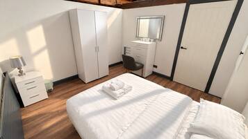 Ein Schlafzimmer mit einem großen Bett, einem Kleiderschrank, einem Schreibtisch und einem Spiegel.