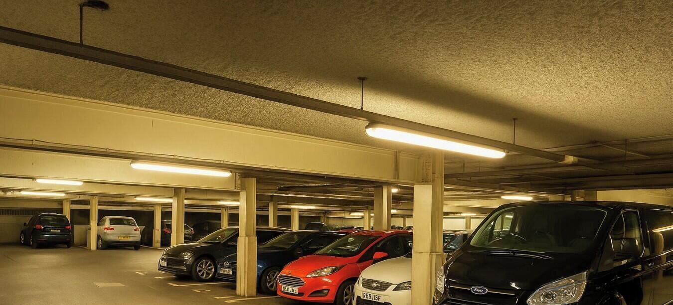 A multi-level underground parking garage with several cars parked.