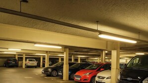 A multi-level underground parking garage with several cars parked.