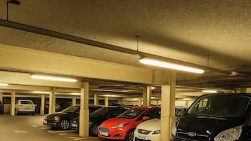 A multi-level underground parking garage with several cars parked.