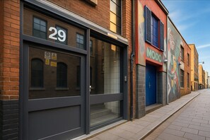 A street view with a building numbered 29, a storefront with a blue door, and a colorful mural on the adjacent building. - City Centre | Sleeps 6 | Bars, Parking & Netflix (Merseyside)