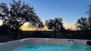 Ein Whirlpool mit freiem Blick auf die umliegende Landschaft und Bäume.