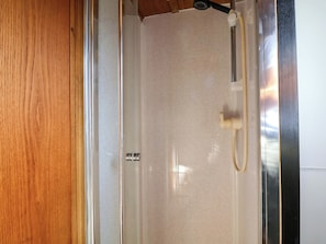 A shower enclosure with a glass door, a showerhead, and a towel rack. - Escape II (Northwich)