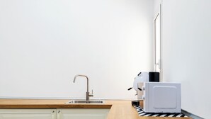 A modern kitchen with a sink, a microwave, and a countertop. - ELORO - Guest Houses (Noto)