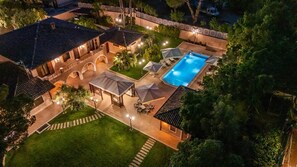 An aerial view of a residential property with a swimming pool, outdoor seating, and a well-maintained lawn. - Luxurious, swimming pool, home theater, elevator, sauna, fitness area, game room (Mascalucia)