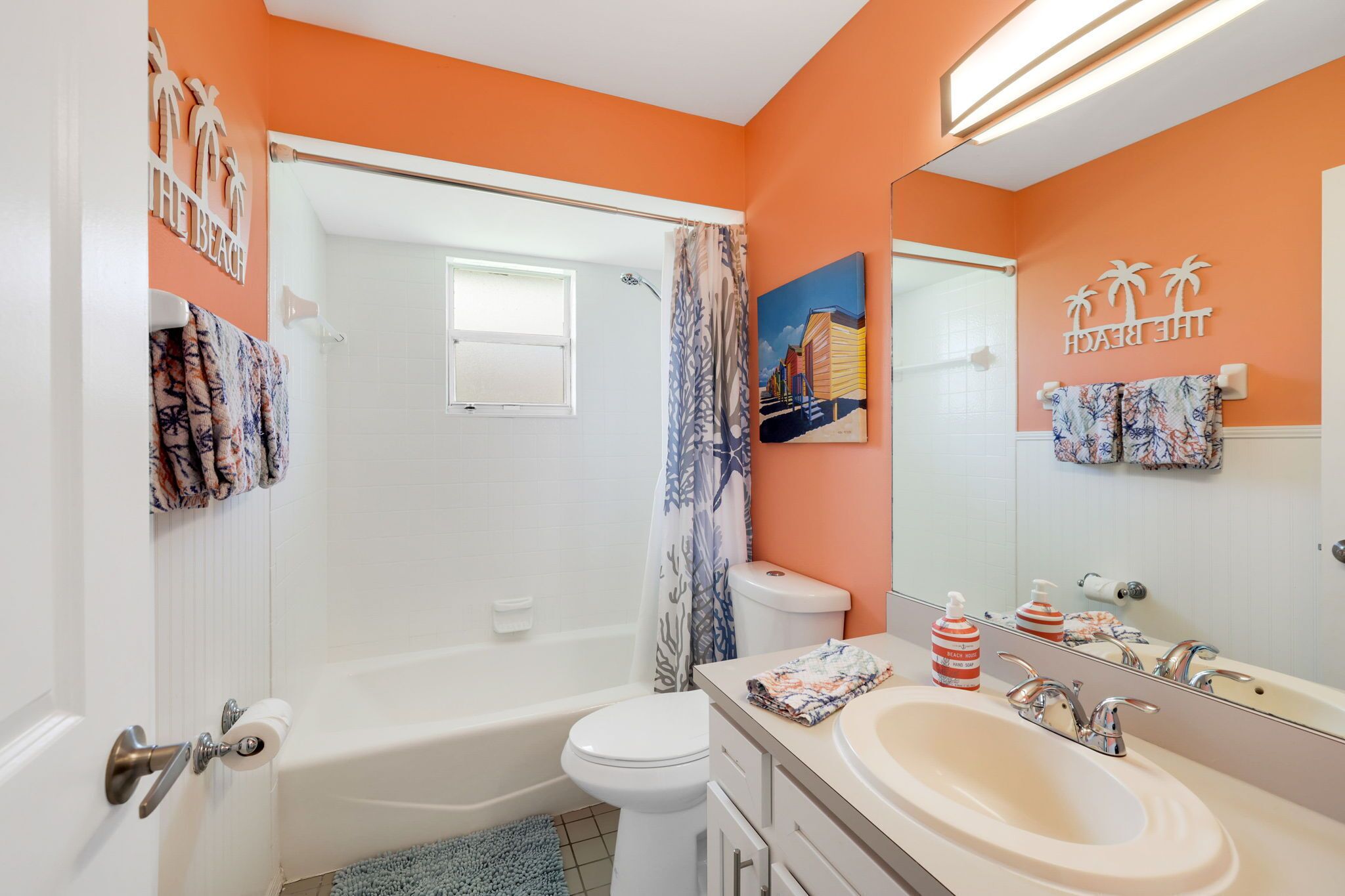 A bathroom with a bathtub, toilet, and sink. There are towels and a shower curtain.