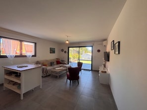 A modern living room with a sofa, a dining table, and a TV. - Apartment with garden in Saint-Raphaël (Saint-Raphaël)
