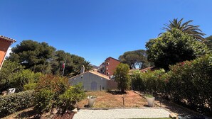 A residential area with houses, a flag, and a clear blue sky. - Apartment with garden in Saint-Raphaël (Saint-Raphaël)