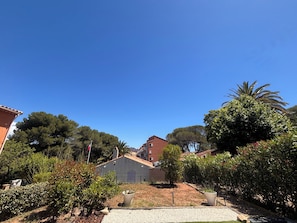 A residential area with houses, a flag, and a clear blue sky. - Apartment with garden in Saint-Raphaël (Saint-Raphaël)