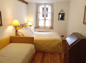 A room with two beds, a window with curtains, a mirror, and a lamp. - House of the Temple - Perfect for 4 people (Briançon)