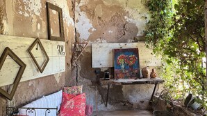A rustic room with a bed, a wooden bench, a chandelier, and a painting on the wall. - The Hôtel Particulier 1900, a 500m² country house in the Var region (Pignans)