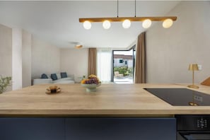 Eine moderne Küche mit einer Holzausziehtafel, einer Obstschale und einer Kaffeemaschine.