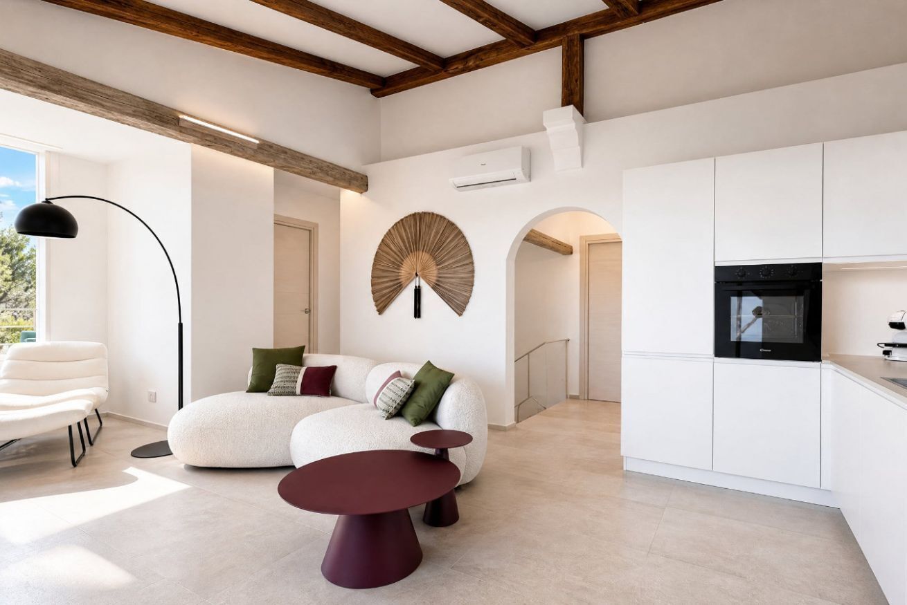 Un espacio habitable moderno con sofá, mesa de comedor y zona de cocina.