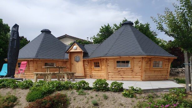 Eine Holzhütte mit geneigtem Dach, einer Holztür und einer kleinen Veranda.
