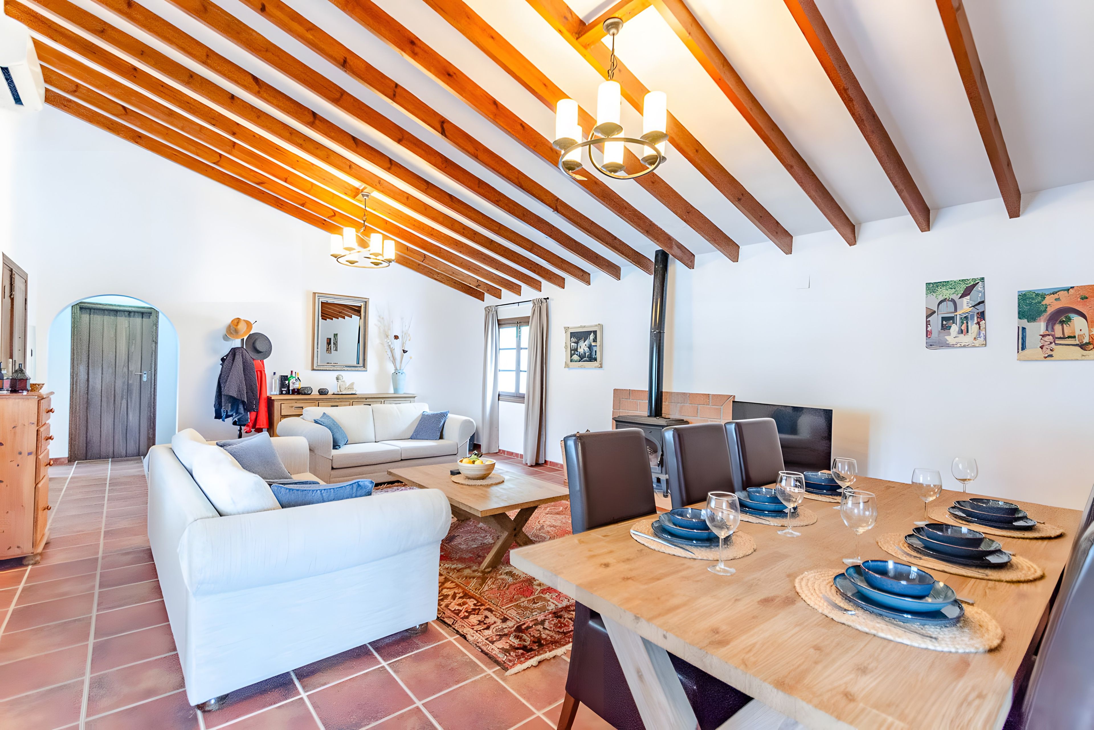 Un amplio espacio habitable con una mesa de comedor para seis personas, una chimenea y un espejo grande.