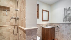 Une salle de bain équipée d’une douche, de toilettes, d’un lavabo et d’un meuble en bois.