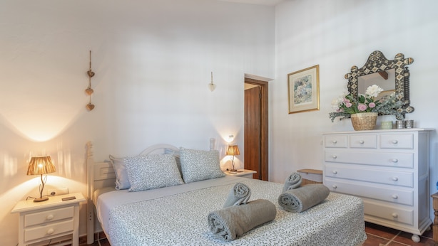 Une chambre à coucher avec un lit, des tables de chevet, une commode et un miroir.