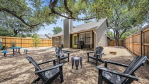 A backyard with Adirondack chairs, a fire pit, and a wooden deck. - Stylish Backyard Retreat BBQ Workspace (Austin)