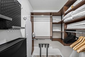 Ein modernes Badezimmer mit Handtuchhalter, Wäscheständer und Ablagefläche mit ordentlich gefalteten Handtüchern.