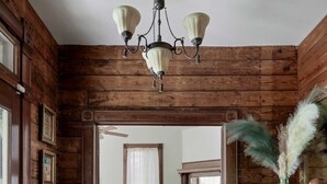 A wooden interior with a chandelier, a blue rug, and a teal dresser. - Charming 5 Bedroom Home in Austin (Austin)