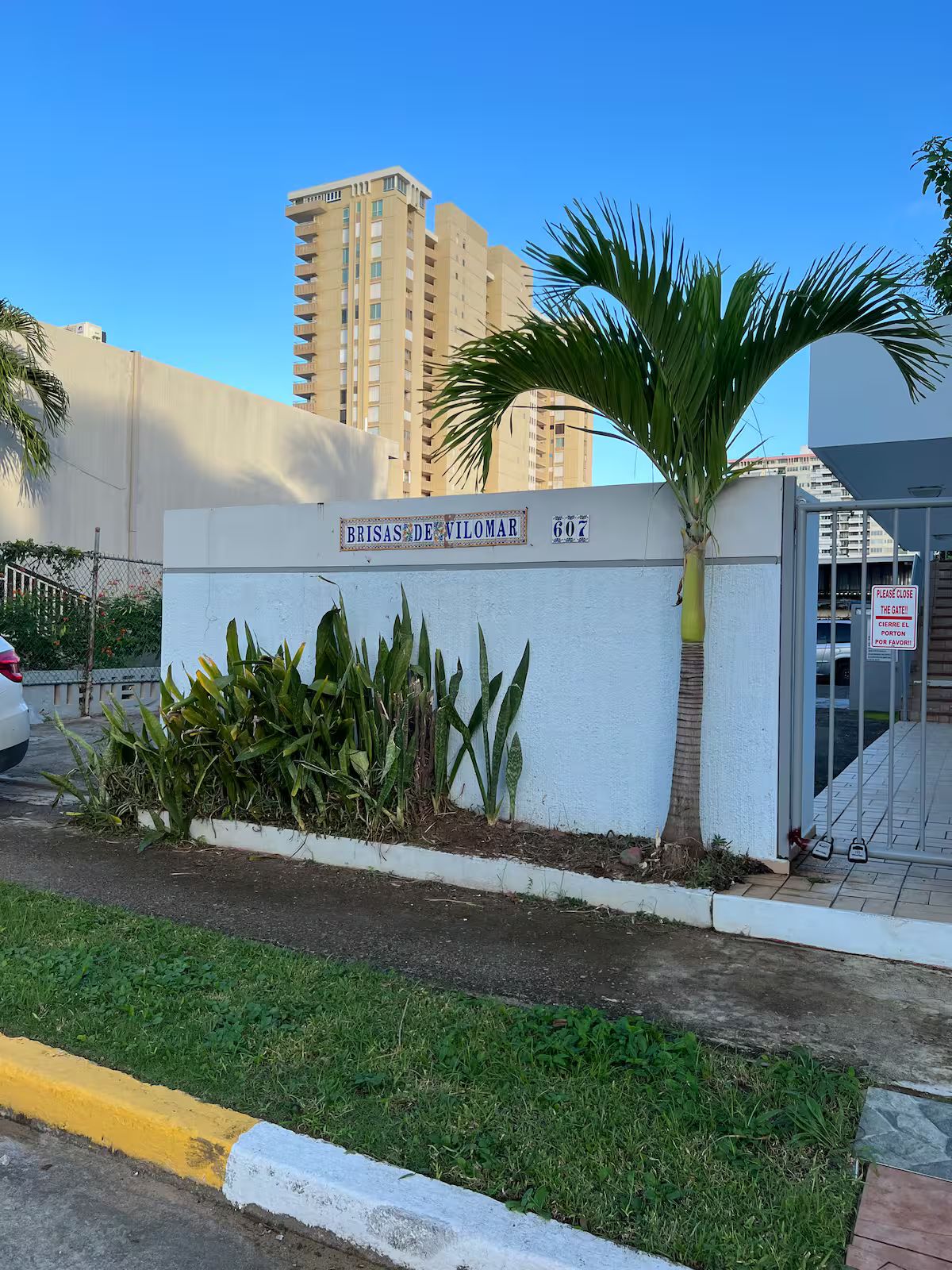 Un edificio con un letrero que dice 'Brisas de Vilomar 607' y una palmera en primer plano.