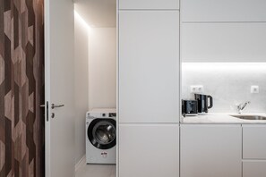 Ein kleiner Hauswirtschaftsraum mit Waschmaschine, Kaffeemaschine und Spüle.