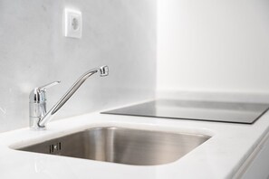 Eine moderne Küche mit Spüle aus Edelstahl und einem eleganten Wasserhahn.