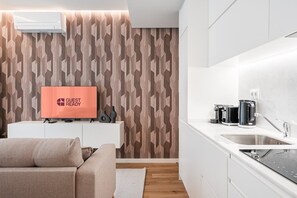Eine moderne Küche mit Backofen, Spüle und einer Arbeitsplatte, auf der sich ein Wasserkocher und ein Toaster befinden.