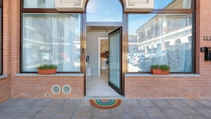 En hotelindgang med store vinduer, en murstensfacade og en dør ind.
