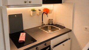 A compact kitchen with a microwave, sink, and oven. - Cozy apartment just outside Paris – Clichy (Clichy)
