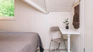 Une chambre à coucher avec un lit, une table et une chaise.