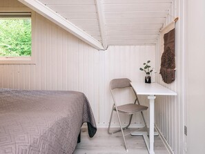A bedroom with a bed, a table, and a chair. - 4 Star Holiday Home in Silkeborg (Silkeborg)