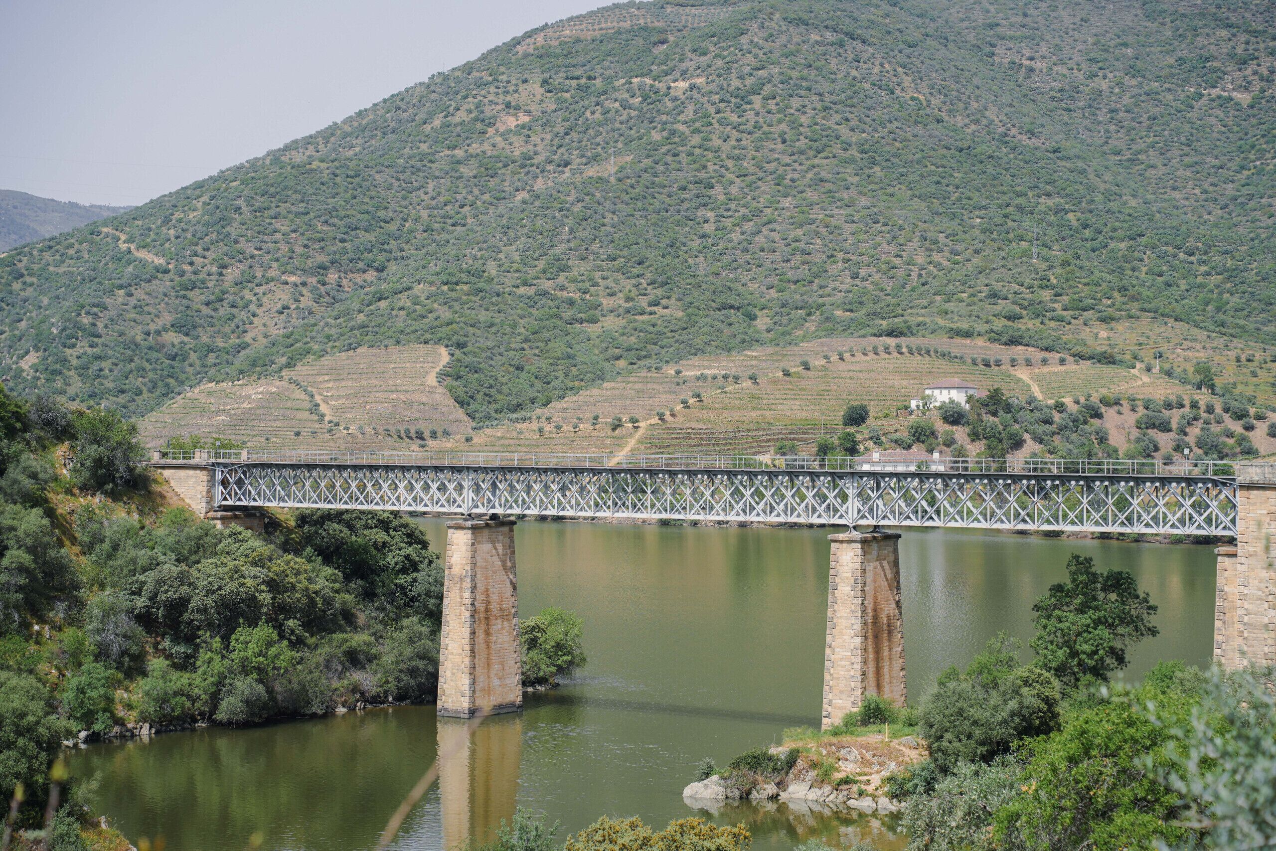 Un pont enjambant une rivière, avec un paysage vallonné en arrière-plan.