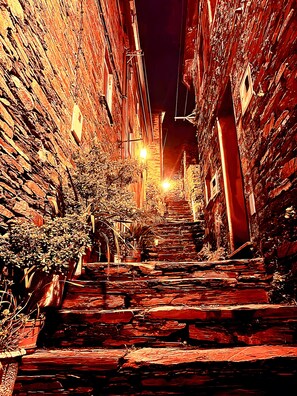 A narrow alleyway with brick walls and potted plants. - Holiday Home 'Refúgio do Xekeraute' with Mountain View, Shared Pool and Wi-Fi (Piódão)