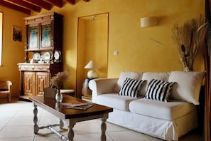 A living room with a sofa, a coffee table, a cabinet with glass doors, and a lamp.