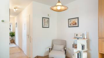 Ein modernes Wohnzimmer mit einer Couch, einem kleinen Bücherregal und einer dekorativen Lampe.