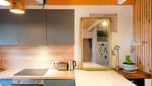 Eine moderne Küche mit einer Holzausziehtafel, einem Toaster, einem Wasserkocher und einem großen Spiegel.
