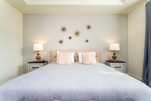 A bedroom with a large bed, two bedside tables, and wall-mounted star decorations. - Modern 9BR Family Villa Pool and Relax (Kissimmee)