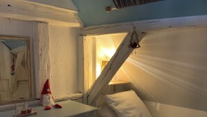 Ein Schlafzimmer mit Etagenbett, Kommode, Spiegel und einer kleinen Weihnachtsdeko.