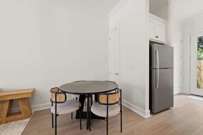 A modern kitchen with a round table, chairs, a bench, and a refrigerator. - Kali House •  River Ranch • Prime Location • Premier Host (Lafayette)