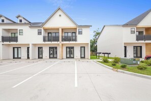 A multi-story residential building with a parking lot in front. - Kali House •  River Ranch • Prime Location • Premier Host (Lafayette)