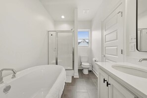 A modern bathroom with a bathtub, toilet, shower, and sink. - Kali House •  River Ranch • Prime Location • Premier Host (Lafayette)